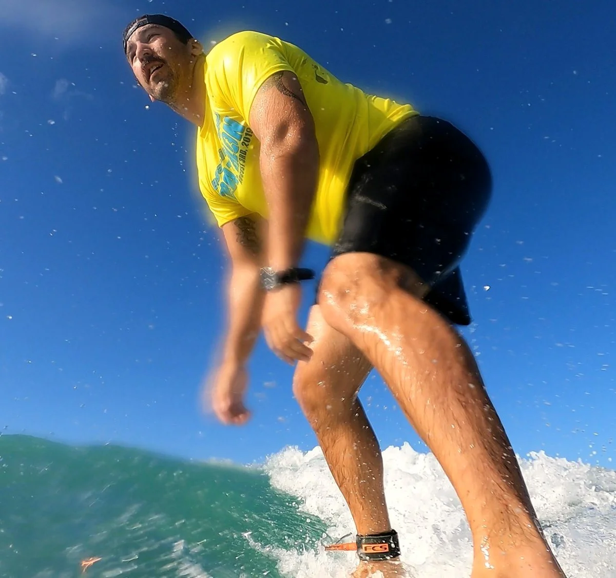 Ryan Adams surfing with spray around his board