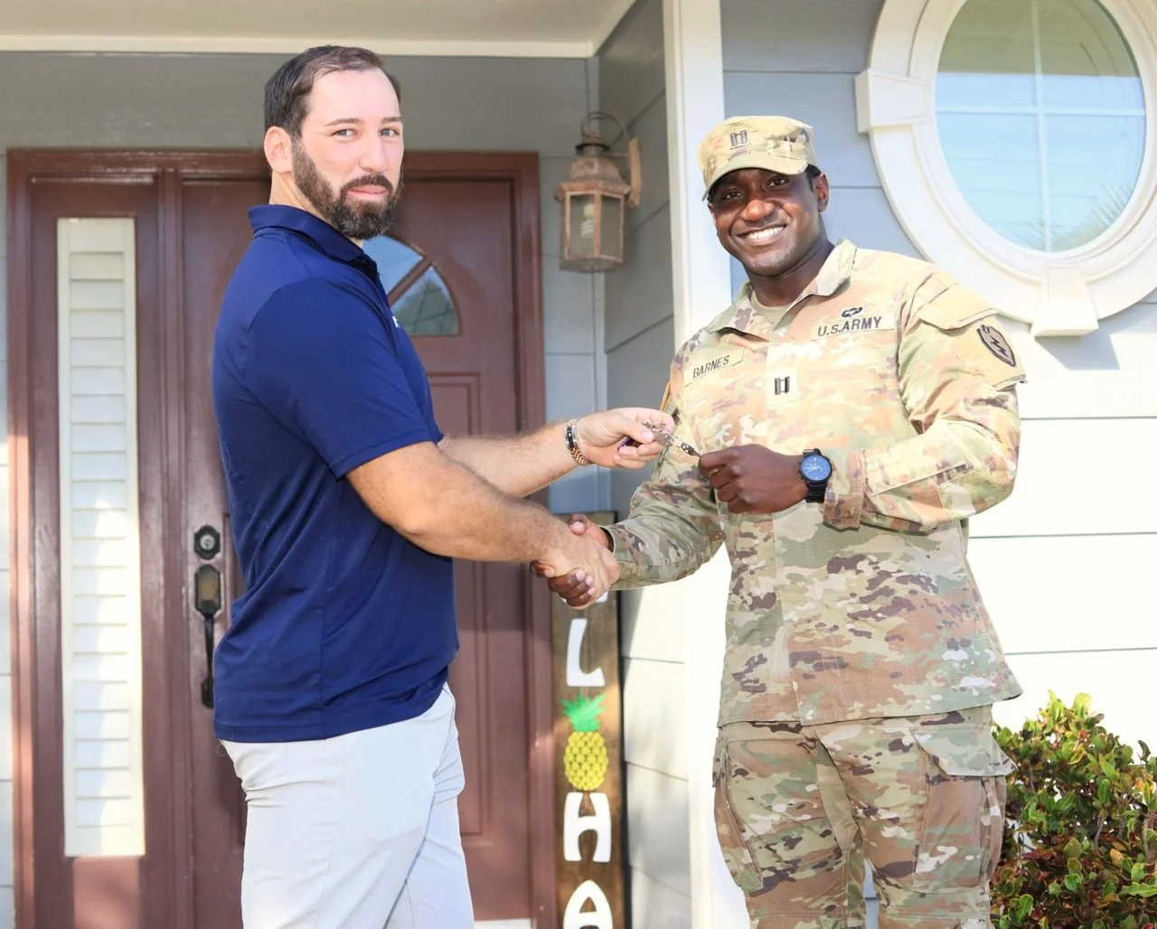 Ryan Adams handing keys to a soldier outside a home
